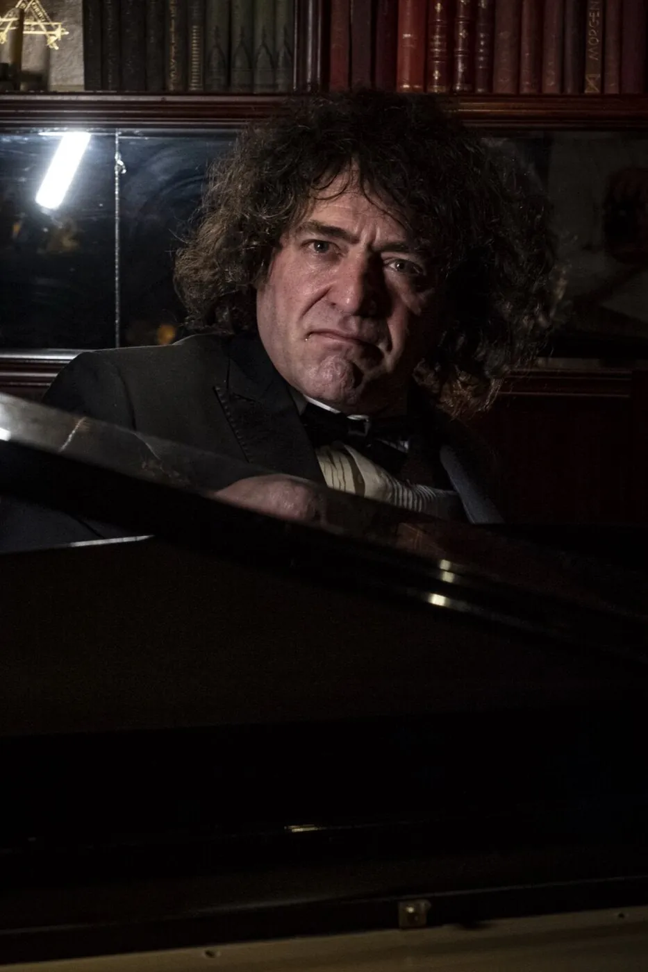 Robin Finesilver resting at the grand piano between numbers
